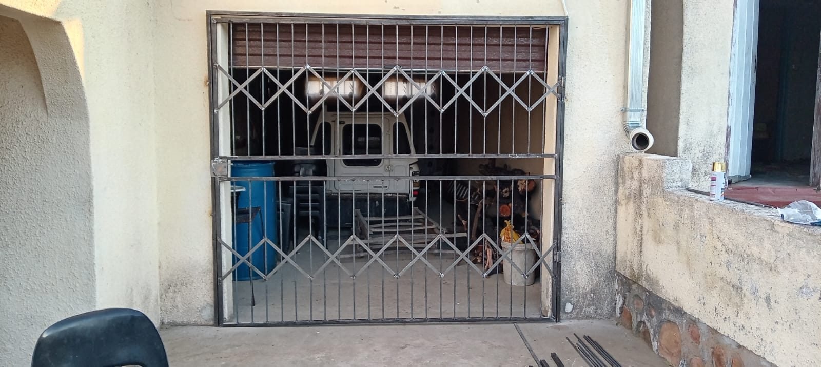 Expandable trellis security gate fitted to a garage opening